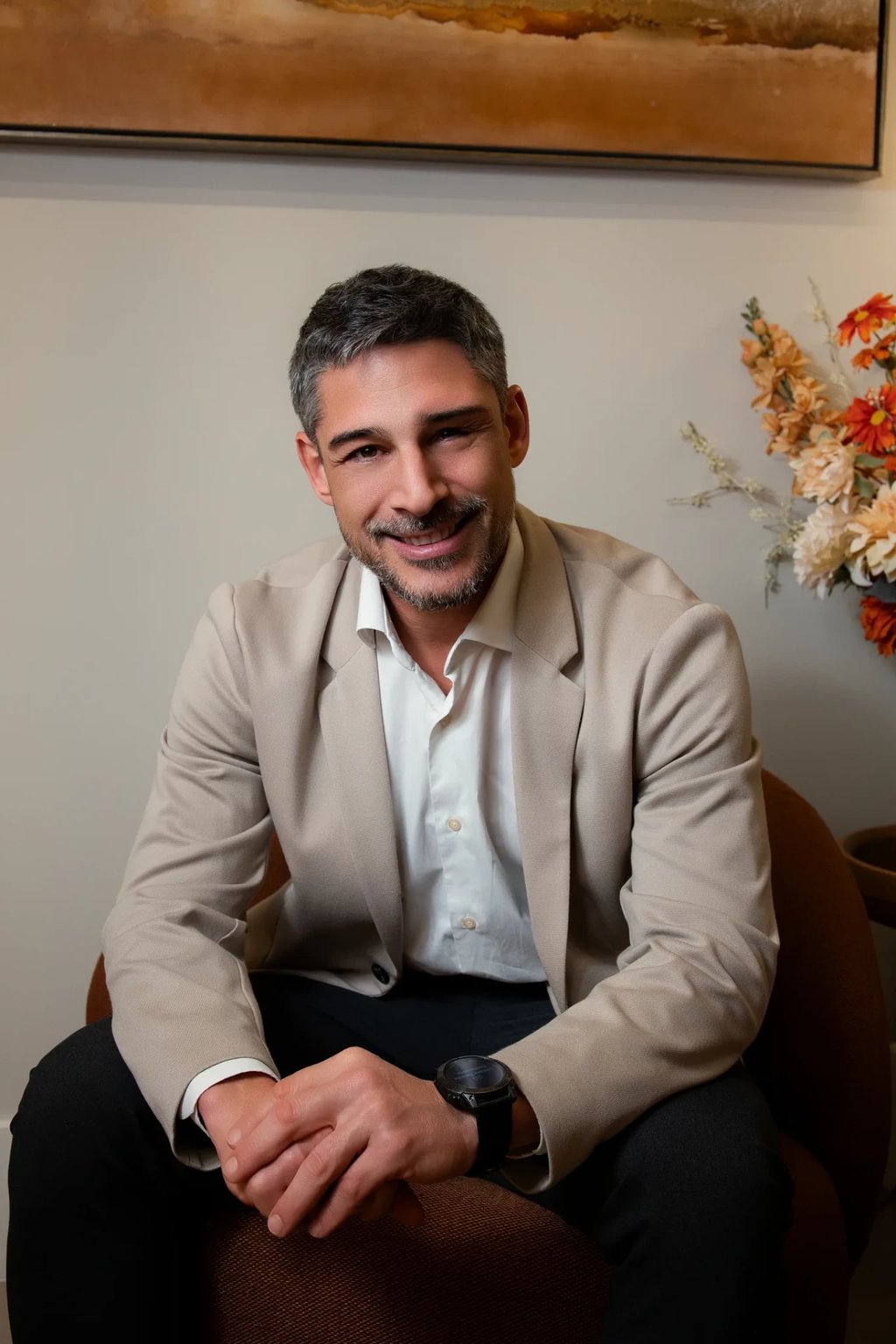 Retrato do Dr. Clóvis Saggiorato, cirurgião vascular e angiologista da Clínica La Vena, sentado na poltrona do consultório